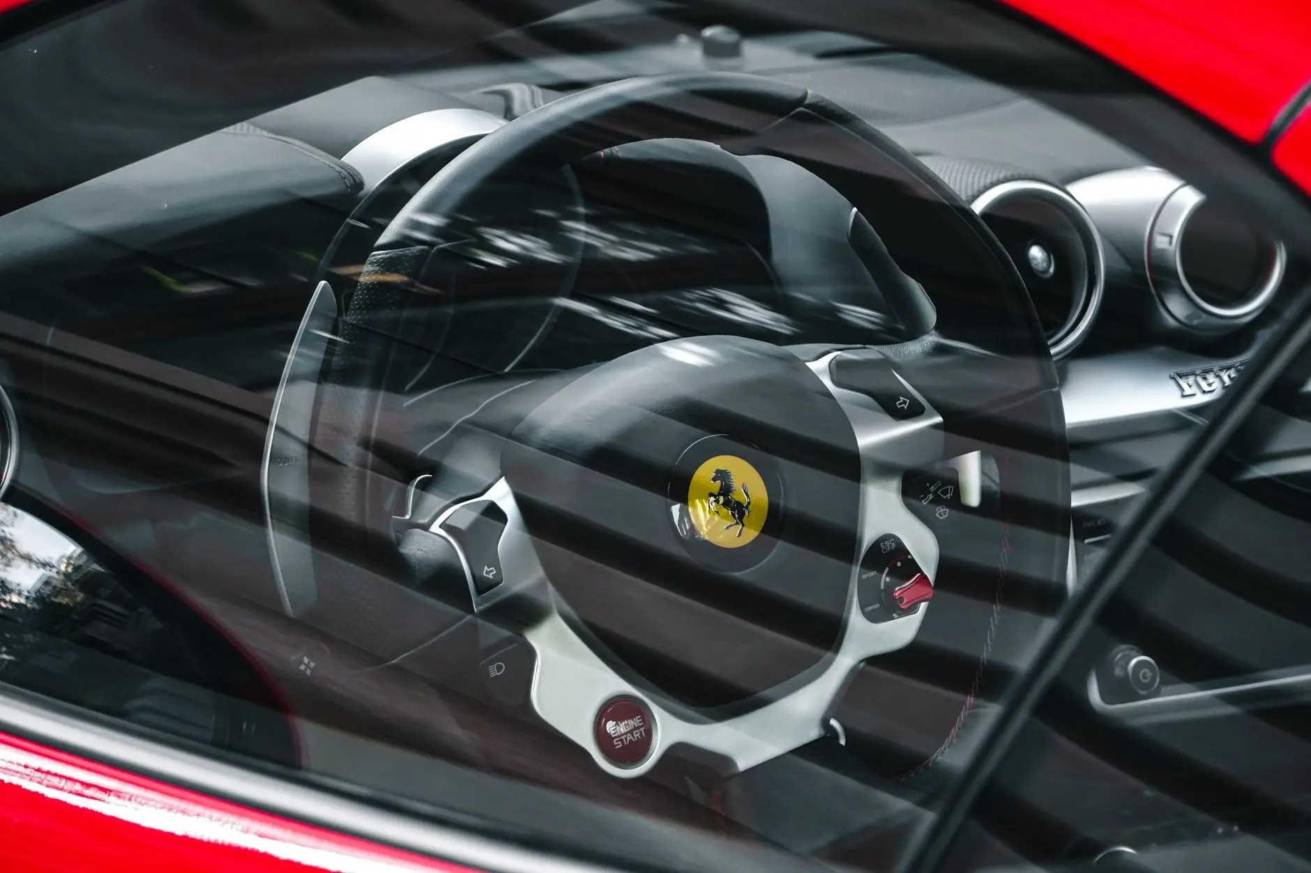 Close-up of a luxury sports car interior showcasing steering wheel through the window.